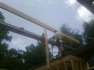 Carpenter setting a ridge beam over a new addition frame — Ice Dam Removal by Roofing Brothers in Orinda