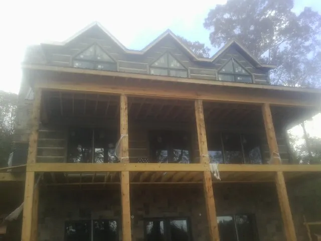 Dormers and porch framing on a large log home under construction — Roof Coating work by our crew in Orinda