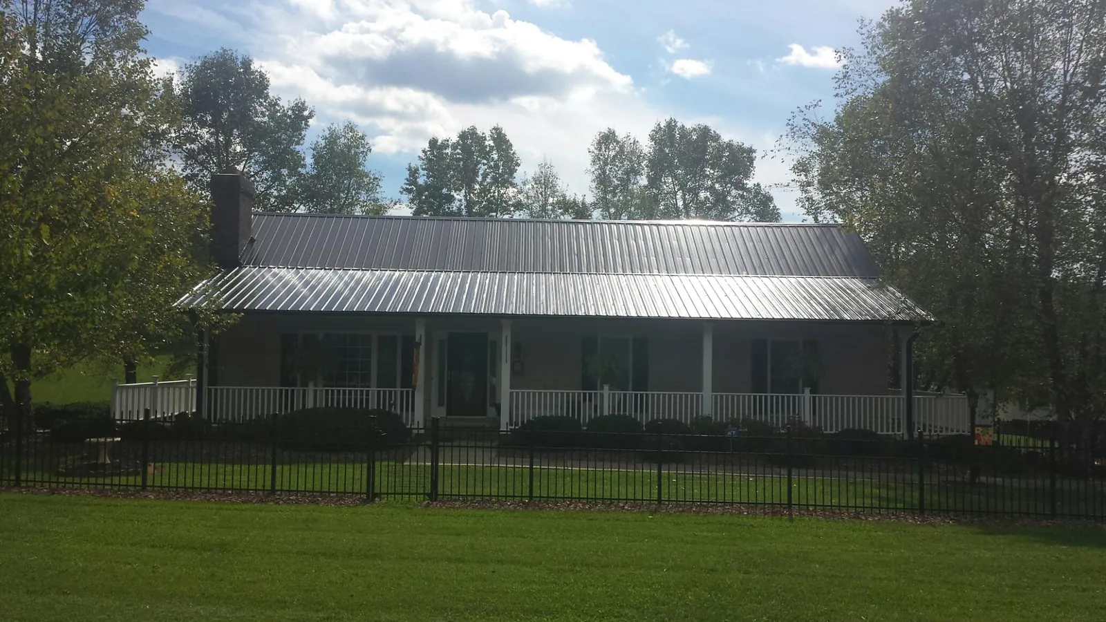 Gray metal roof on a brick ranch with a full width front porch — Gutter Guard Installation work by our crew in Orinda